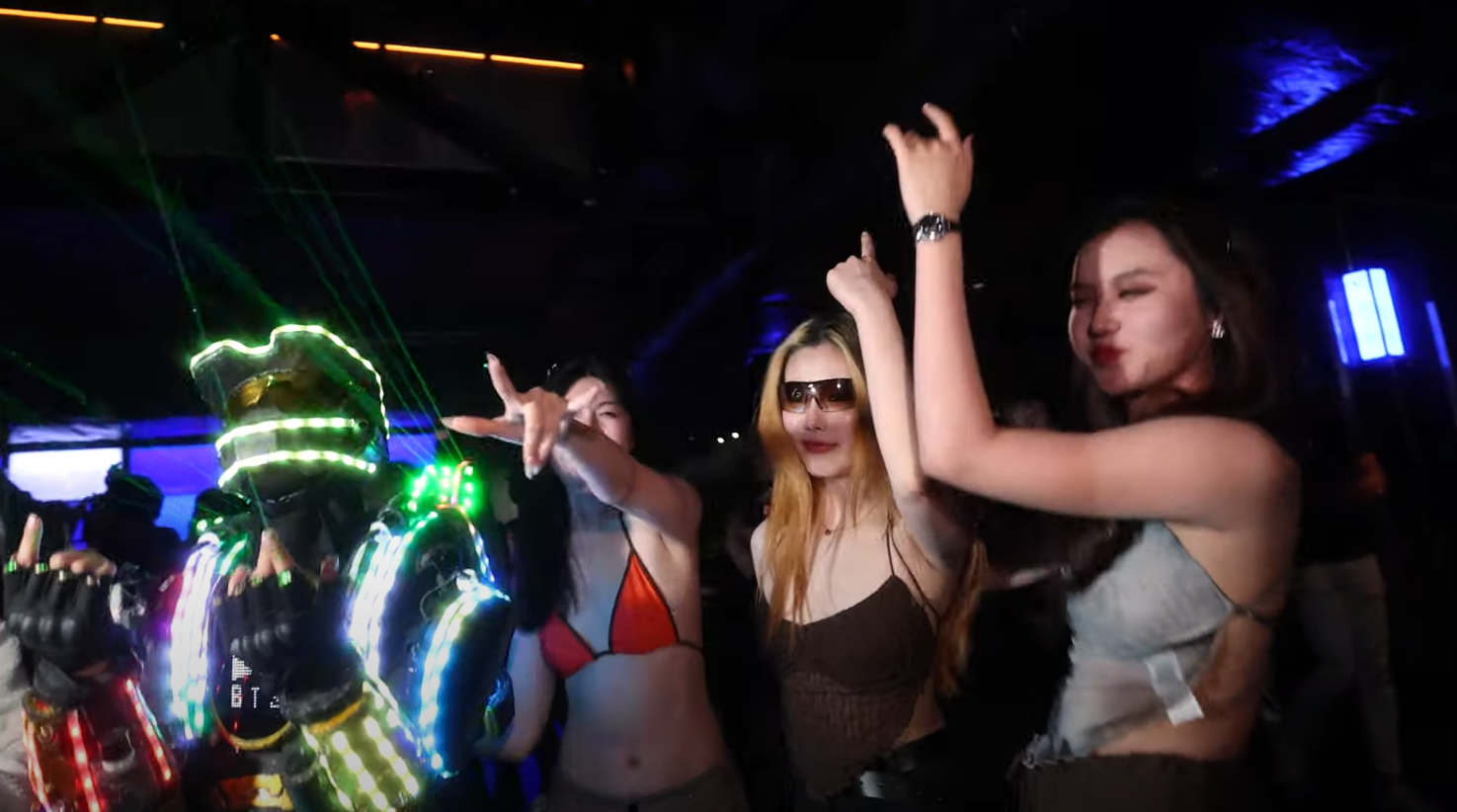 three girls and an LED costume dancing in night club